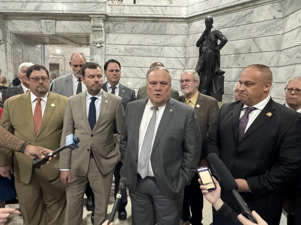 Lawmakers stand in the Capitol Rotunda.